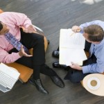 Overhead View Of Two Businessmen Having Meeting In Office Lobby